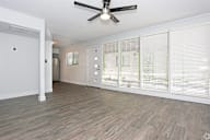 A room with a ceiling fan and wooden flooring. at Palm Villas, Scottsdale, 85257