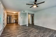 A room with a ceiling fan and wooden flooring. at Palm Villas, Arizona