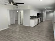 A kitchen with white cabinets and a ceiling fan.