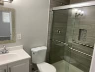 A white toilet sits next to a sink in a bathroom.