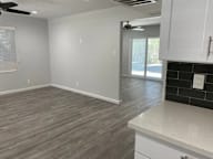 A kitchen with white cabinets and a ceiling fan.
