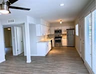 A spacious kitchen with white cabinets and stainless steel appliances.