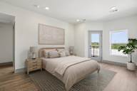 A bedroom with a large bed, a nightstand with a lamp, and a painting on the wall.