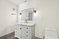 A white bathroom with a vanity and a toilet.