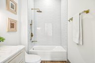 A white bathroom with a toilet, sink, and bathtub.