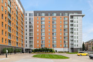 a large apartment building on a street with a parking lot at Verge Apartments in St. Louis Park, MN