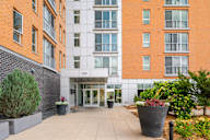 the entrance to an apartment building with a walkway and plants at Verge Apartments in St. Louis Park, MN