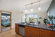 an open kitchen and living room with a bedroom in the background at Verge Apartments in St. Louis Park, MN