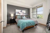 a bedroom with a bed and a large window at Verge Apartments in St. Louis Park, MN