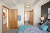 a bedroom with a bed and a door to a bathroom at Verge Apartments in St. Louis Park, MN