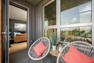 a porch with two chairs and a table and windows at Verge Apartments in St. Louis Park, MN