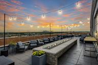 A rooftop patio with a fire pit and seating area.