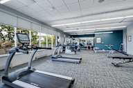 A gym with treadmills, exercise bikes, and other equipment.