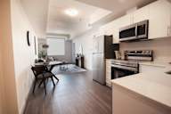 A kitchen with a refrigerator, oven, and microwave.