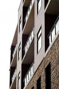 A tall building with a balcony on each floor.