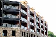 A multi-story building with balconies and windows under construction.
