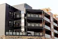 A modern multi-story building with black and brown balconies.