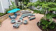 A patio with a table and chairs and a blue umbrella.