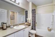 A bathroom with a toilet, sink, and bathtub.
