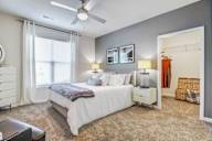 A bedroom with a large bed and a ceiling fan.
