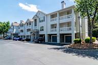 A large white building with a parking lot in front.