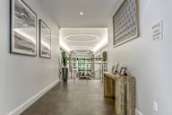 A long hallway with a wooden bench and pictures on the wall.