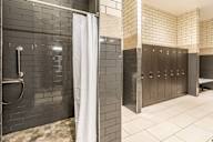 A bathroom with a shower and a row of stalls.