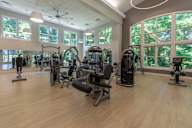 A gym with a variety of equipment and a large window.