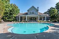 A house with a pool in front of it.