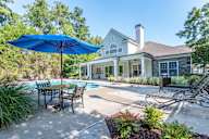 A house with a pool and a blue umbrella.