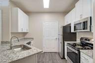 A kitchen with a sink, refrigerator, and stove.
