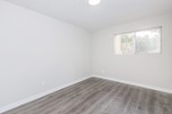 Room with a window and wooden flooring.