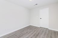 Room with a white door and grey flooring.