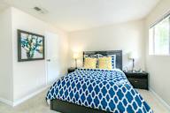 Bedroom with a large bed and a painting on the wall.