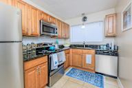 Kitchen with wooden cabinets and black countertops.