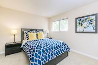 Bedroom with a bed, nightstand, and a painting on the wall.
