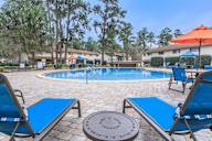 Pool surrounded by blue lounge chairs and umbrellas.