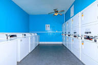 Room with white appliances and a ceiling fan.