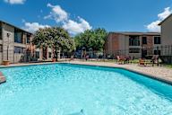 Swimming pool in a residential area with a blue sky and some clouds.