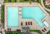 An aerial view of a swimming pool surrounded by a concrete wall.