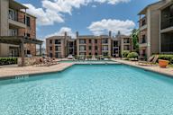 A large swimming pool in front of apartment buildings.