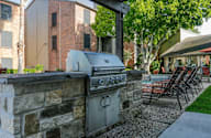 A stone wall with a grill on top of it.