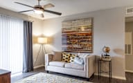 Living room with a couch, a ceiling fan, and a painting on the wall.