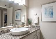 A bathroom with a white sink and a mirror.