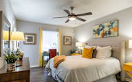 A bedroom with a large bed and a ceiling fan.