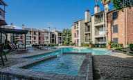 A swimming pool surrounded by apartment buildings.