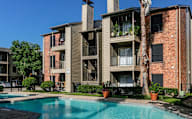 A large apartment complex with a pool in front.
