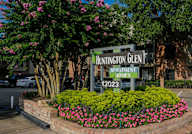 A sign for Huntington Glen Apartment Homes stands in front of a building.