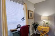 Room with a desk, chair, and a window with blinds.