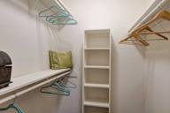 A white closet with a shelf and hangers.